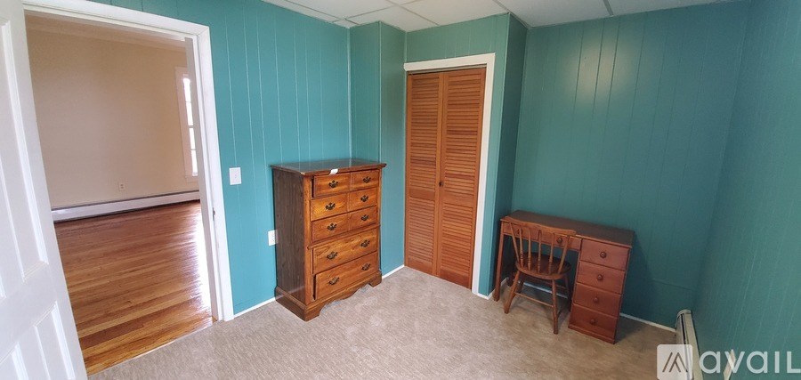 A room with a wooden dresser and a chair.