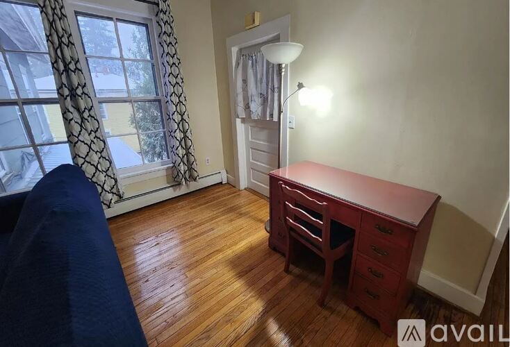 A room with a red desk and a blue couch.
