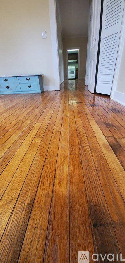 A long hallway with wooden floors and white walls.