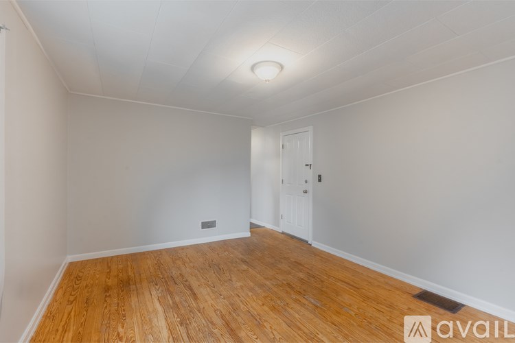 A room with wooden flooring and a white door.