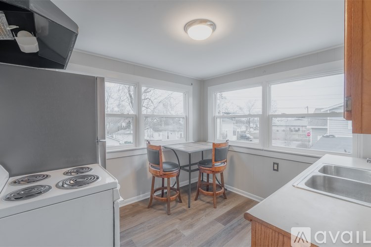 A kitchen with a stove, sink, and a window.