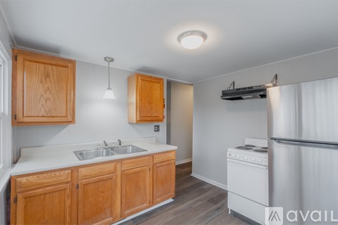 A kitchen with wooden cabinets and a white stove top oven.