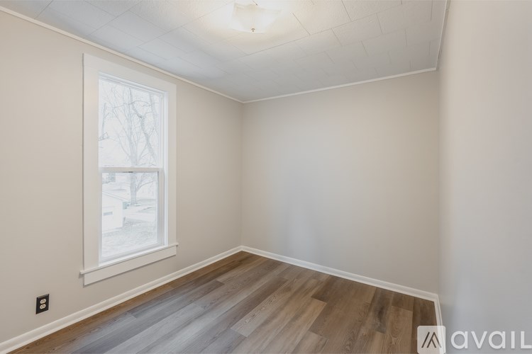 A room with a window and wooden flooring.