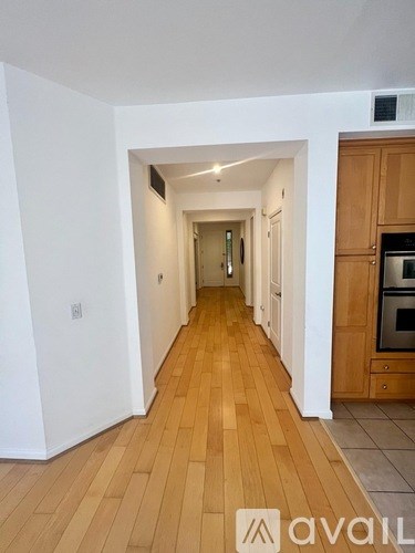 A long hallway with wooden floors and white walls.