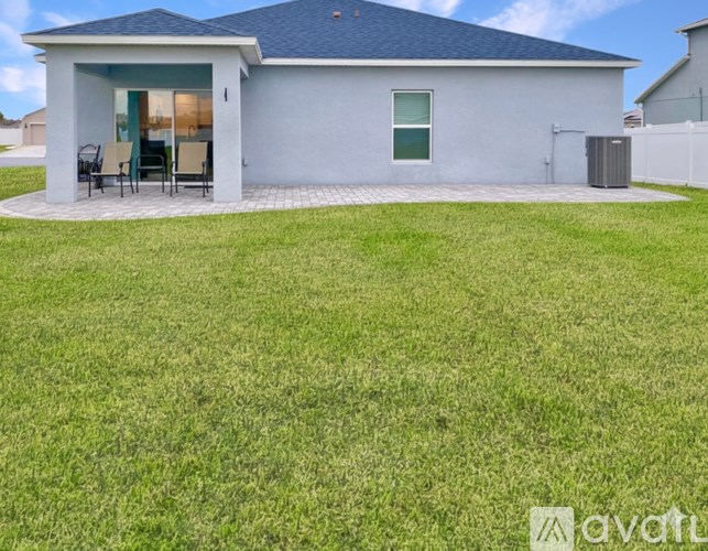 A house with a blue roof and a white fence.