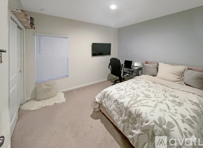 A bedroom with a large bed and a flat screen TV mounted on the wall.