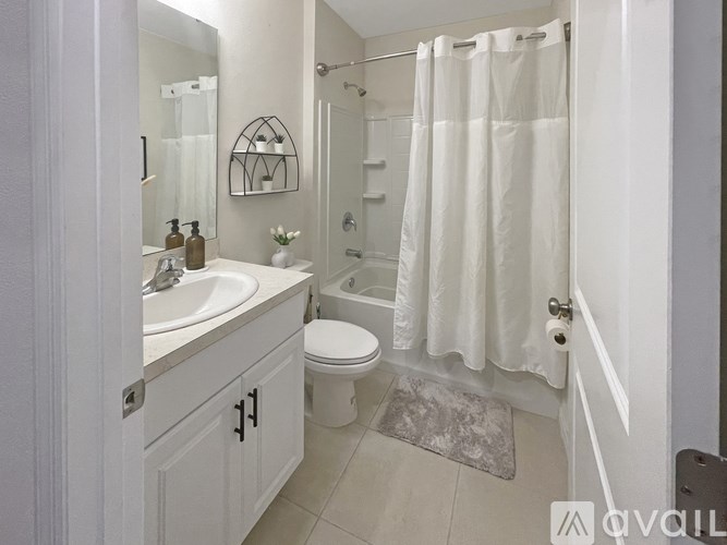 A white bathroom with a toilet, sink, and shower.
