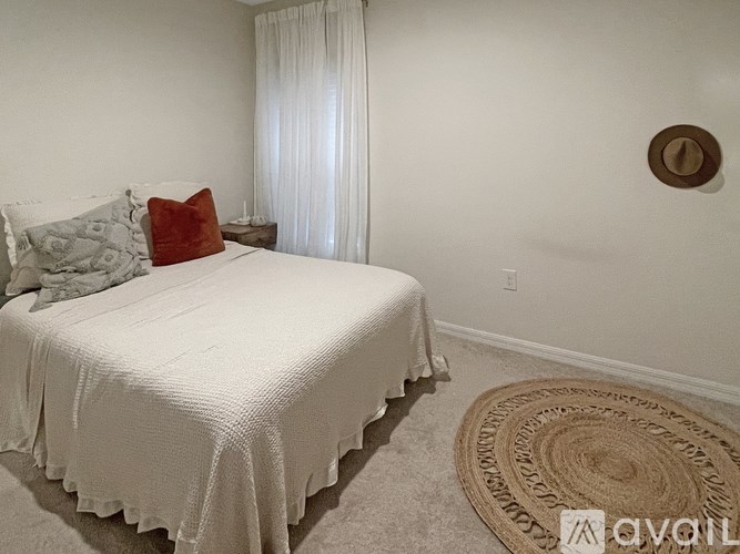 A bedroom with a white bed and a white curtain.