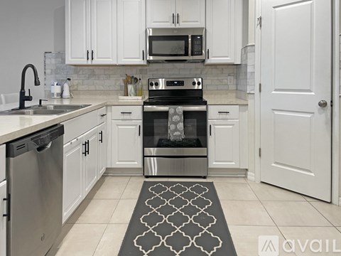 A modern kitchen with a stove top oven and microwave above it.
