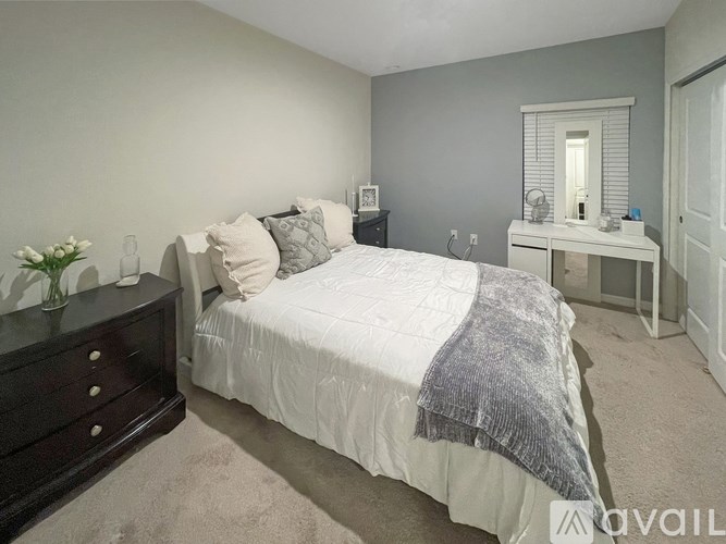 A bedroom with a bed, nightstand, and a dresser.
