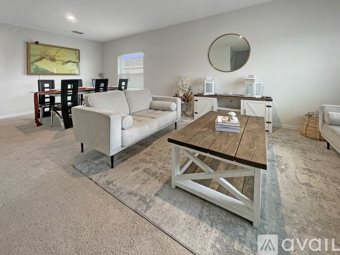 A living room with a couch, chairs, and a coffee table.
