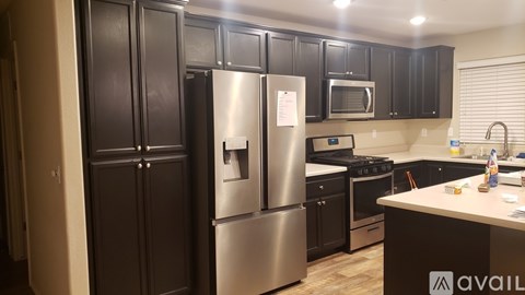 A kitchen with black cabinets and stainless steel appliances.