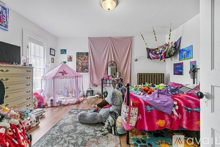 A child's bedroom with a pink canopy bed and a canopy tent.