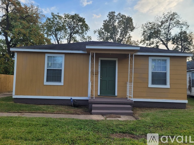 A small house with a green door and two windows is available for rent.