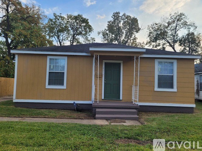 A small house with a green door and two windows is available for rent.