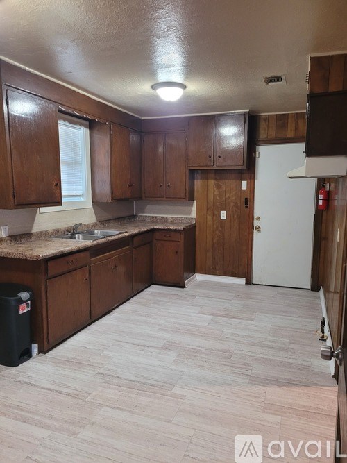 A kitchen with wooden cabinets and a white fridge.