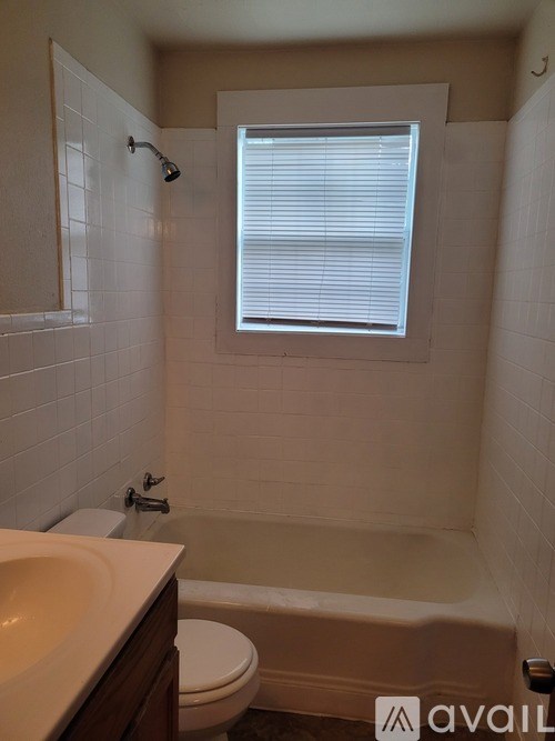 A bathroom with a toilet, sink, and bathtub.