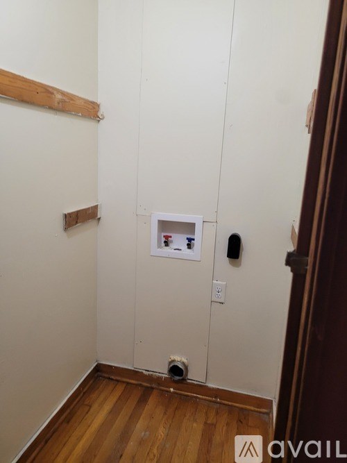 A small white box with a red and blue sticker on it is on a white wall.