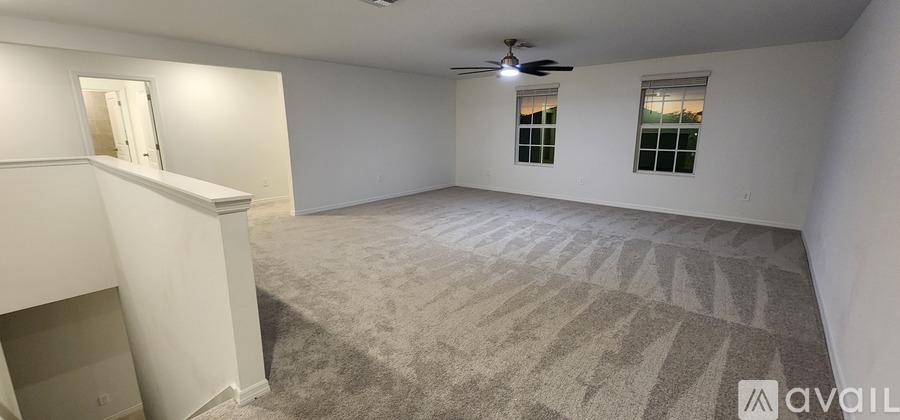 A living room with a white sofa, a wooden table, and a ceiling fan.