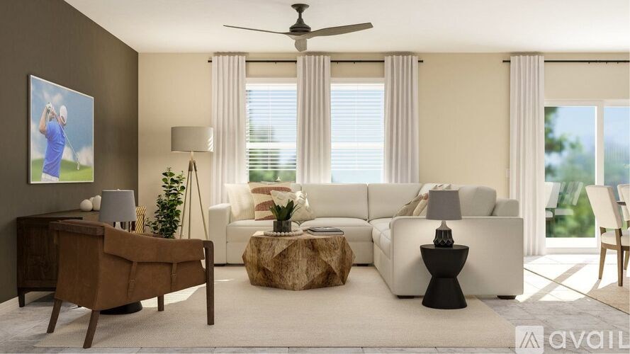 A modern living room with a white sofa, a wooden desk, and a ceiling fan.