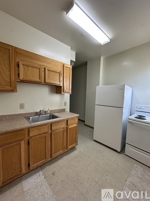 A kitchen with wooden cabinets and a white refrigerator.