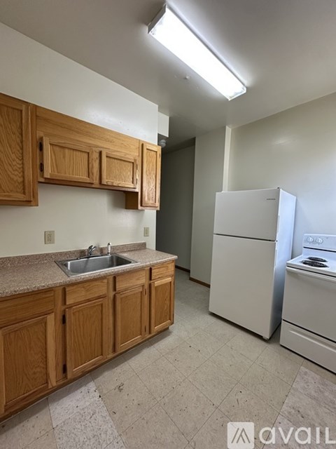 A kitchen with wooden cabinets and a white refrigerator.