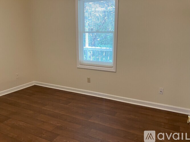 A room with wooden flooring and a window.