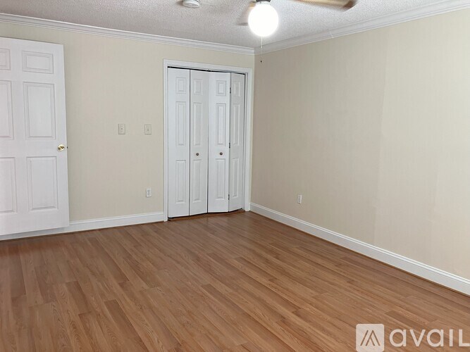 A room with wooden flooring and two doors.