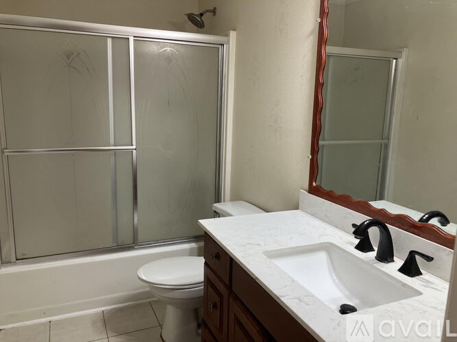 A bathroom with a toilet, sink, and shower.