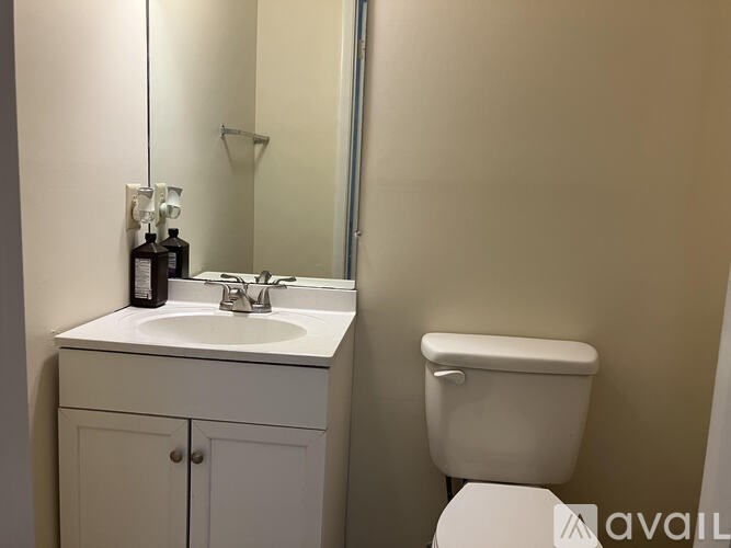 A bathroom with a toilet, sink, and cabinet.
