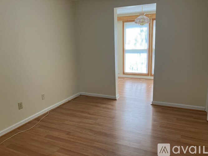 A room with wooden flooring and a window.