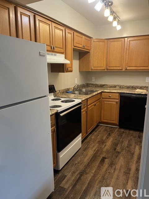 A kitchen with wooden cabinets and a white refrigerator.