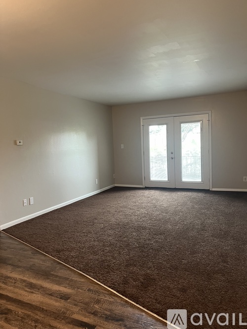 A room with a carpeted floor and a door with a window.