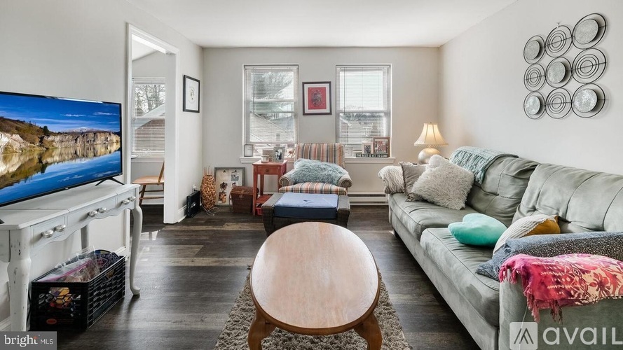 A living room with a couch, a coffee table, and a television.