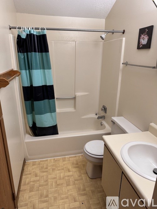 A bathroom with a toilet, sink, and shower.