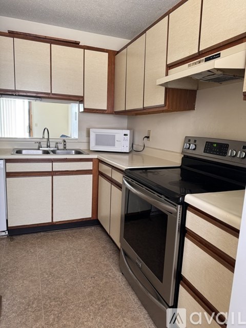 A kitchen with a black oven and white cabinets.