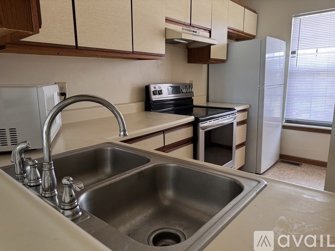 A kitchen with a sink, stove, and refrigerator.