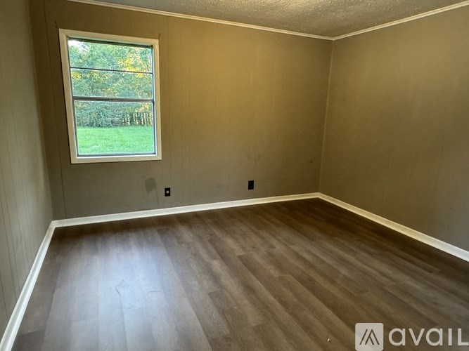 A room with a window and wooden flooring is available for rent.