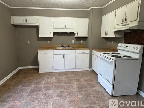 A kitchen with white appliances and cabinets.