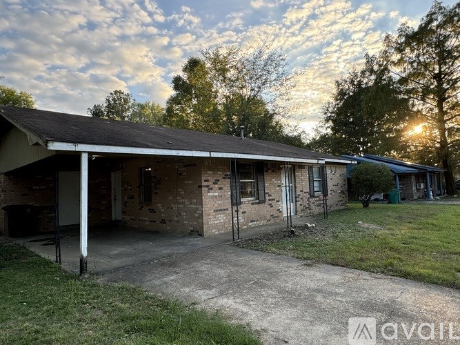 A house with a porch and a driveway in front of it.
