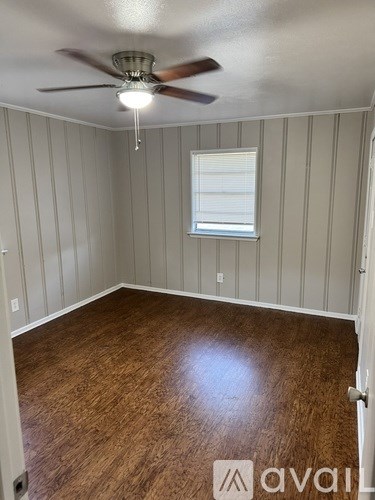 A room with wooden flooring and a ceiling fan.