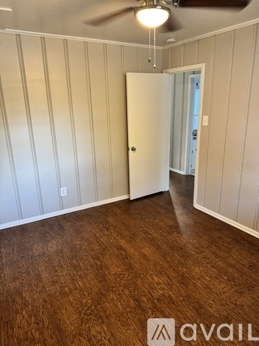 A room with wood flooring and a white door.