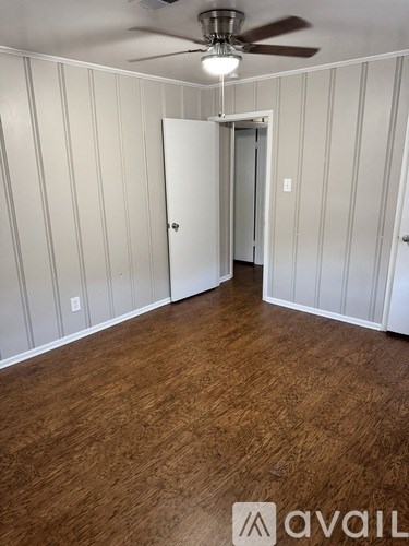 A room with wood flooring and a ceiling fan.