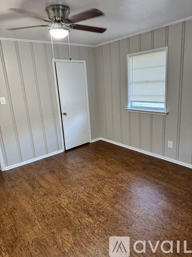 A room with wooden flooring and a ceiling fan.