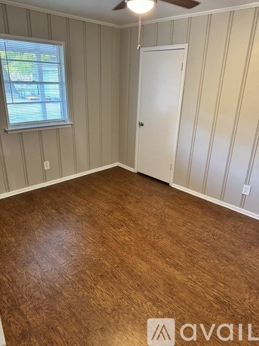 A room with wooden flooring and a window.