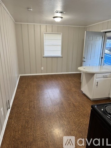 A room with wooden flooring and a white cabinet.
