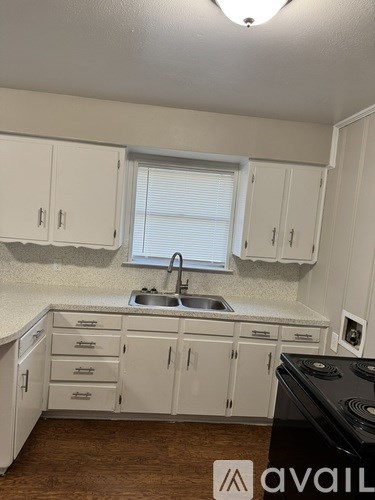A kitchen with white cabinets and a black stove top.