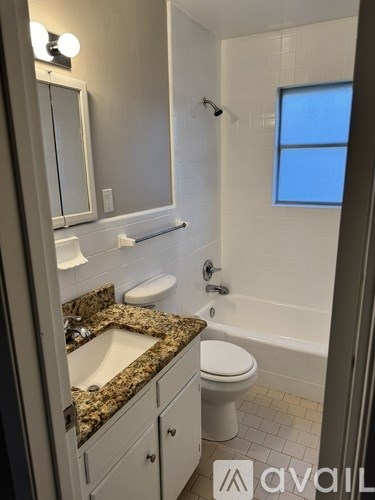 A bathroom with a sink, toilet, and bathtub.