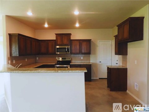 A kitchen with brown cabinets and a white island.