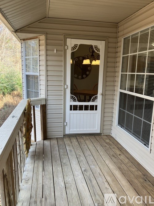 A wooden deck with a white door and window.